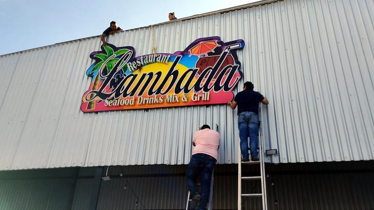 Personal realizando instalación de anuncio comercial